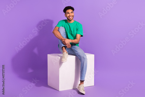 Full body photo of young handsome guy dream thoughts about next job sit platform box looking empty space isolated over purple background