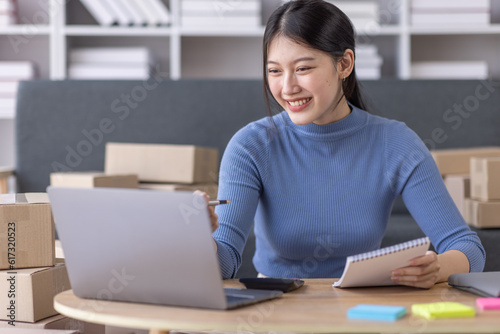 Portrait of Starting small businesses SME owners female entrepreneurs working on receipt box and check online orders to prepare to pack the boxes, sell to customers, SME business ideas online. 