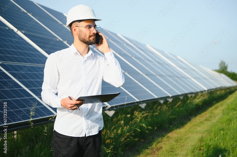 Young architect standing by solar panels