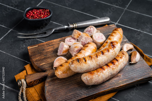 German grilled Bratwurst pork meat sausages on a wooden board. Wooden background. Top view