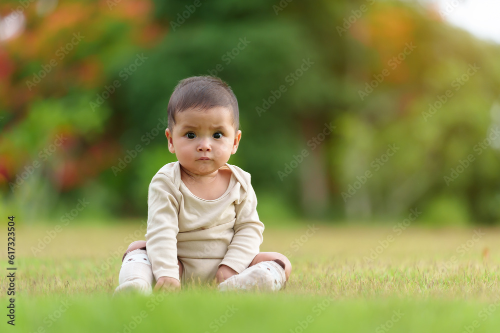 infant baby sitting on green grass field at the park infant baby sitting on green grass field at the park