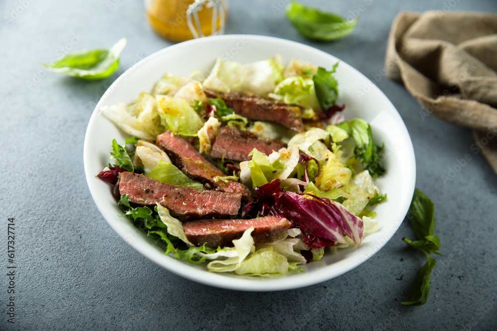 Green salad with beef steak and mustard dressing