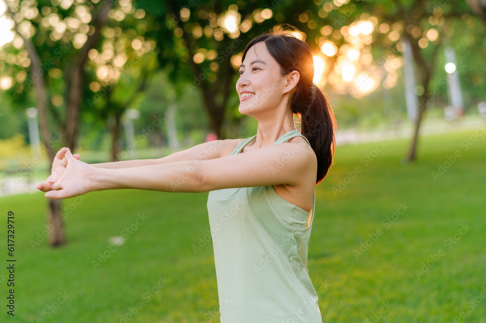 Female jogger. Fit young Asian woman with green sportswear stretching muscle in park before running and enjoying a healthy outdoor. Fitness runner girl in public park. Wellness being concept Female jogger. Fit young Asian woman with green sportswear stretching muscle in park before running and enjoying a healthy outdoor. Fitness runner girl in public park. Wellness being concept