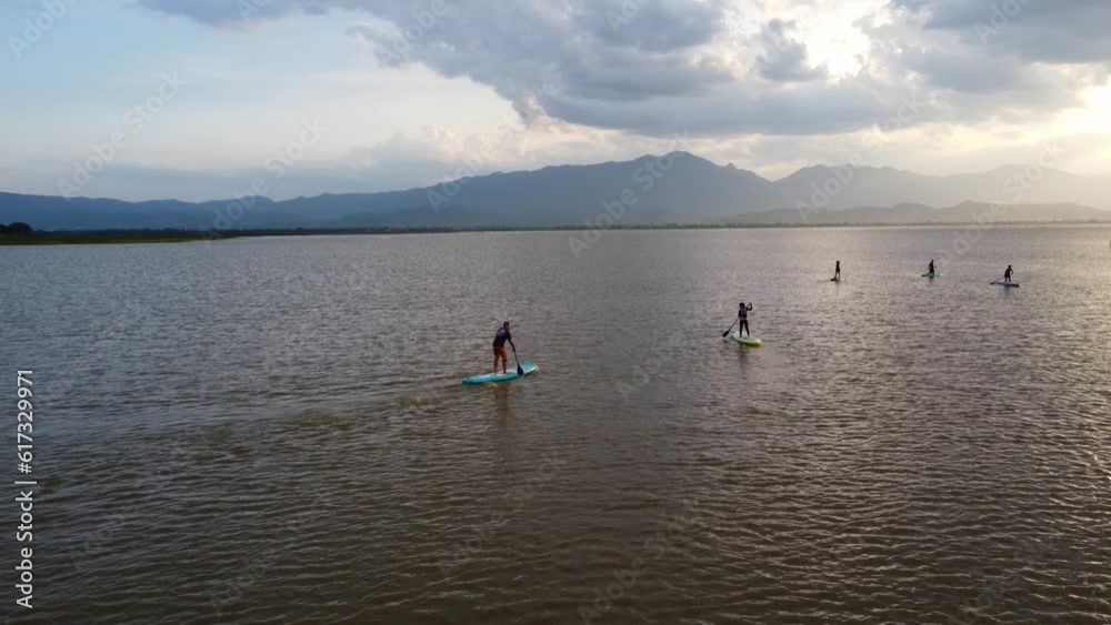 Experience the serene beauty of people paddling boarding on a tranquil lake. Embrace the active lifestyle, explore nature, joy and relaxation. Phayao Lake, Thailand. Experience the serene beauty of people paddling boarding on a tranquil lake. Embrace the active lifestyle, explore nature, joy and relaxation. Phayao Lake, Thailand.