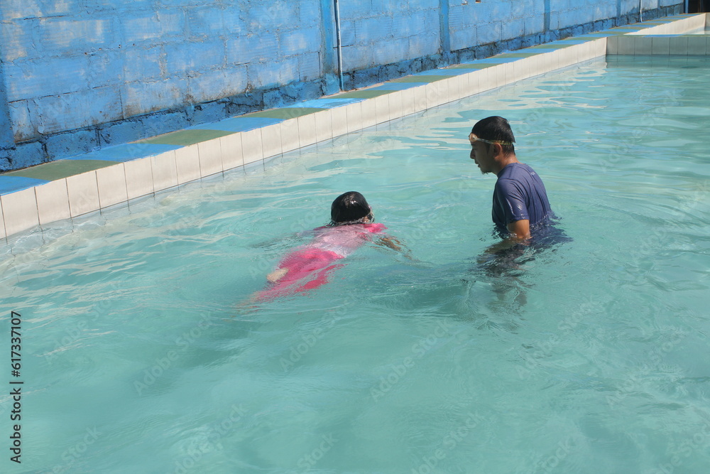 boys and girls practice swimming and playing in water
