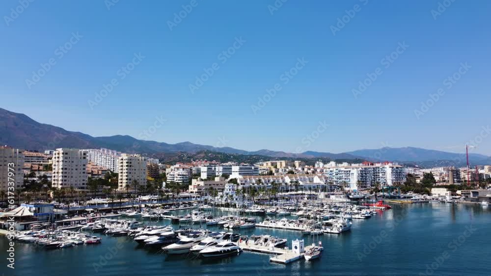 A drone pulls back for the Estepona skyline overlooking the harbor waters. A drone pulls back for the Estepona skyline overlooking the harbor waters.