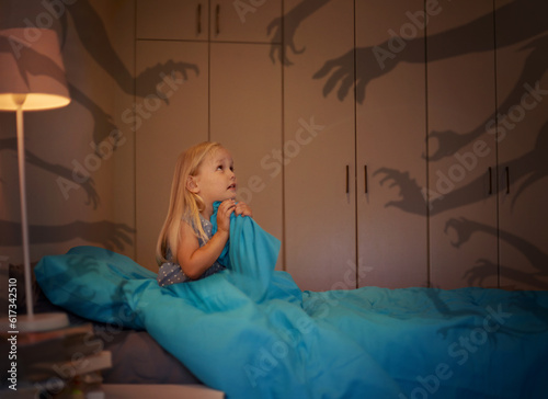 Bilde på lerret Fear, shadow and monster with a girl in bed at night feeling afraid or scared of the dark