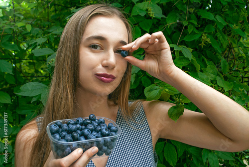 Portrait of smiling woman with blueberry. Benefits of blueberries to improve vision