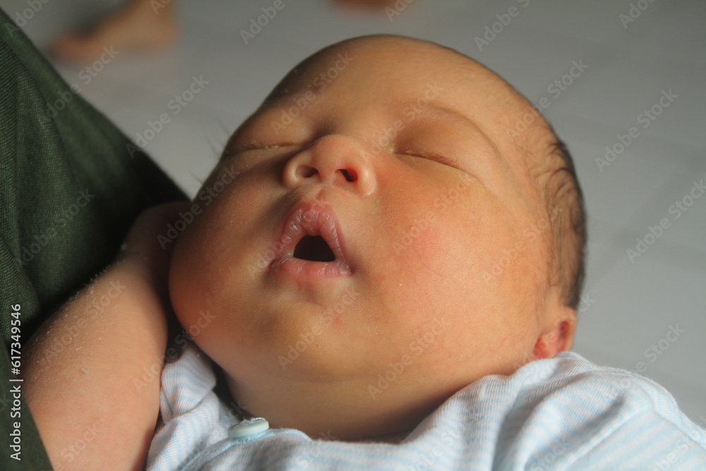 Portrait of a newborn boy who sleeps sweetly and smiles in he sleep in red clothes at a photo shoot of newborns
Portrait of a newborn boy who sleeps sweetly and smiles in he sleep in red clothes at a photo shoot of newborns