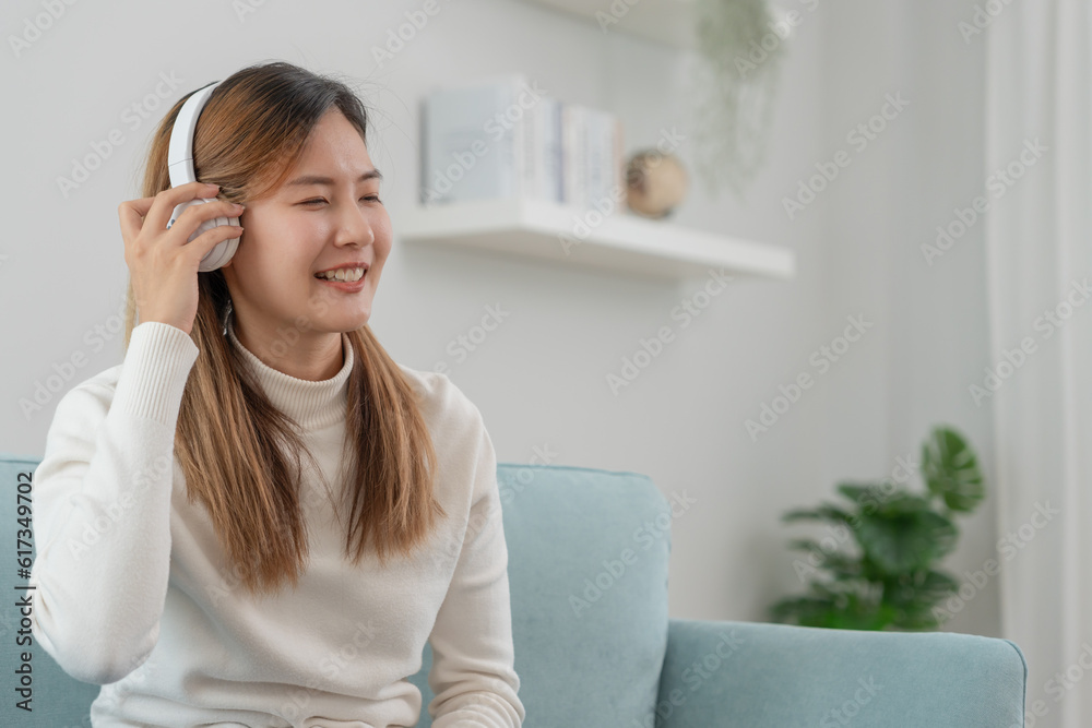 Joyful young Asian women in wireless headphones sitting and enjoy music, having fun, listening to music, raising his arm, dancing to favorite song, enjoying cool soundtrack, happy life, recreation Joyful young Asian women in wireless headphones sitting and enjoy music, having fun, listening to music, raising his arm, dancing to favorite song, enjoying cool soundtrack, happy life, recreation