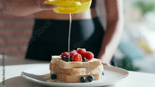 Video of sporty young woman making a delicious and healthy toasts in the kitchen at home. photo