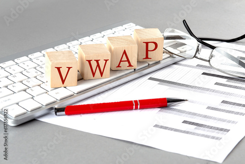 VWAP written on a wooden cube on the keyboard with chart on grey background photo