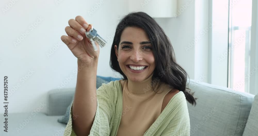Beautiful Brazilian woman showing keys from new apartment, close up. Happy homeowner or tenant enjoy relocation day to own house, smile look at camera. Bank loan, affordable dwelling owner portrait Beautiful Brazilian woman showing keys from new apartment, close up. Happy homeowner or tenant enjoy relocation day to own house, smile look at camera. Bank loan, affordable dwelling owner portrait