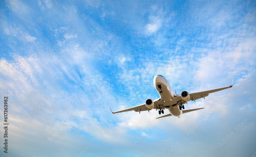 White passenger airplane flying in the sky amazing clouds in the background - Travel by air transport