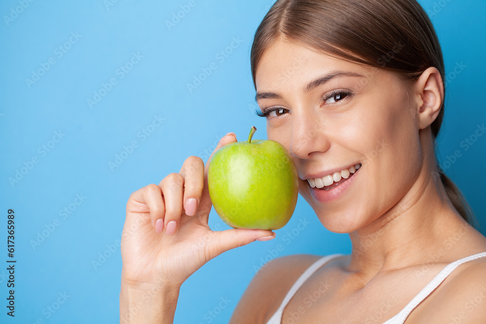 Young woman with snow-white smile holding green apple, teethcare. Young woman with snow-white smile holding green apple, teethcare.