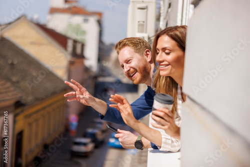 Casual business colleagues looking through office window while on coffee break