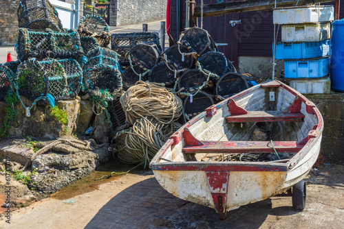 Row boat and lobster pots at a small boatyard at Peveril Point, on the shore or Swanage Bay - Swanage, UK.