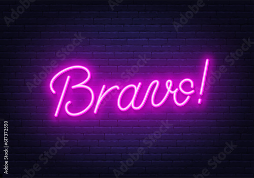 Bravo neon sign on brick wall background.