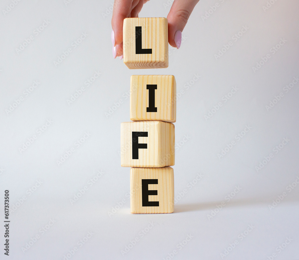 Life symbol. Concept word Life on wooden cubes. Businessman hand. Beautiful white background. Business and Life concept. Copy space. Life symbol. Concept word Life on wooden cubes. Businessman hand. Beautiful white background. Business and Life concept. Copy space.