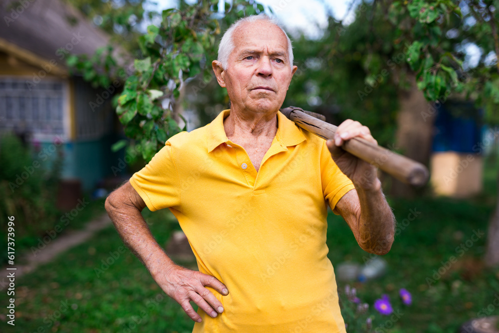 Obraz premium Portrait of a man with a shovel in the garden
