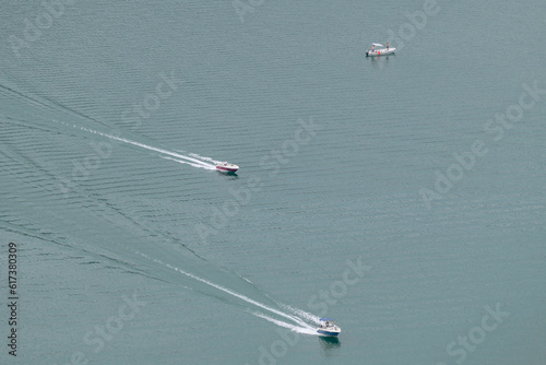 Three motorboats, two of which are in motion, seen from above, Lake Lugano, Switzerland-Italy border photo