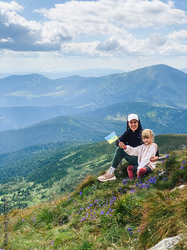 Mom and girl hiking on a mountain © phpetrunina14