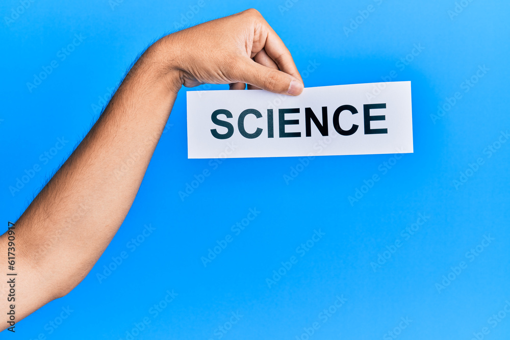 Hand of caucasian man holding paper with science word over isolated blue background Hand of caucasian man holding paper with science word over isolated blue background