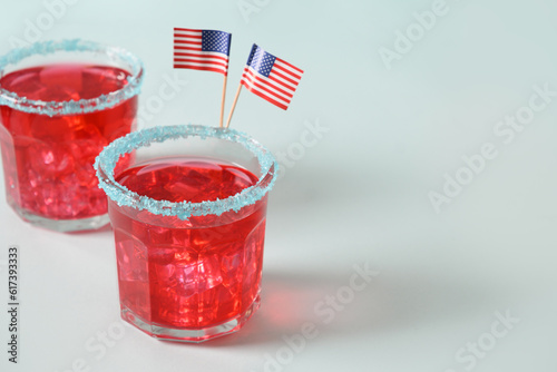 Patriotic red pomegranate margarita two cocktails with blue rim sugar on blue background. Rimmed drinks. Close up. Copy space. photo