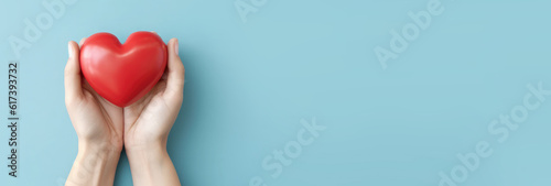 Red heart in man's hands isolated on blue background. Healthcare and hospital medical concept. Symbolic of Valentine day.Top view with space for text. Banner.Generative AI