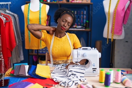 African american woman tailor stressed using sewing machine at sewing studio