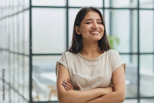 portrait of a smiling business woman with her arms crossed against the backdrop of the office