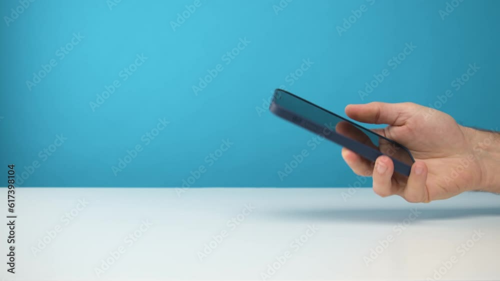 homme en train d'utiliser un smartphone dans sa main sur fond de studio