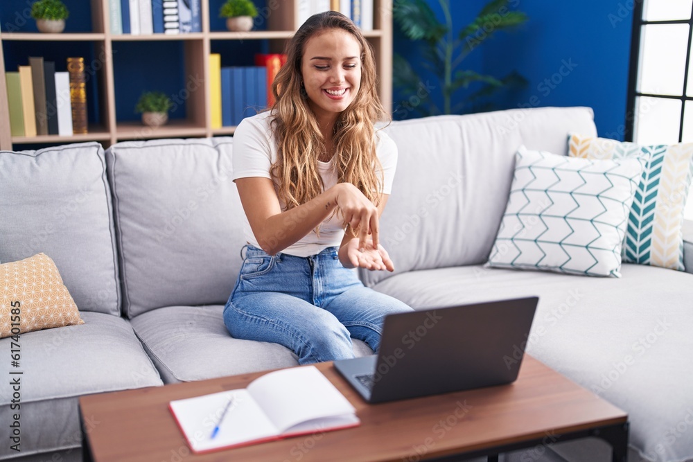 Young beautiful hispanic woman having video call communicate with sign deaf language at home