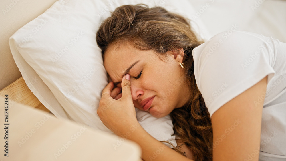 Young beautiful hispanic woman lying on bed crying at bedroom Young beautiful hispanic woman lying on bed crying at bedroom