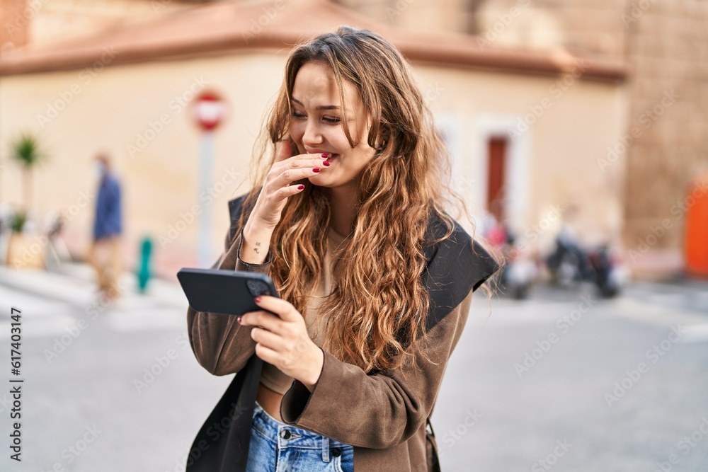 Fototapeta premium Young beautiful hispanic woman smiling confident watching video on smartphone at street