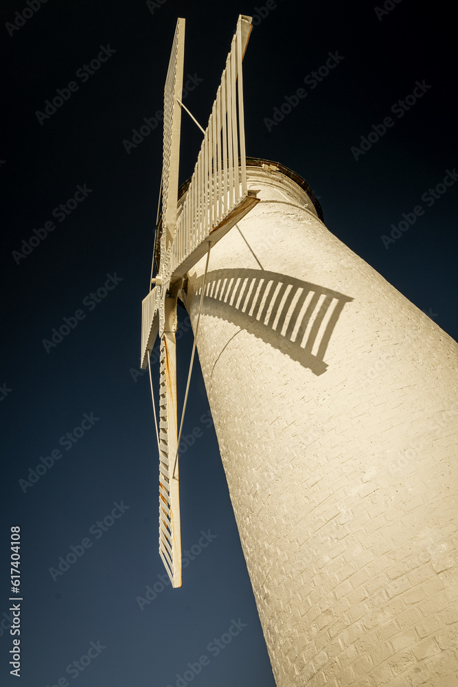 Znak nawigacyjny w kształcie białego wiatraka usytuowany na końcu Falochronu Zachodniego na wyspie Świnoujście.  - obrazy, fototapety, plakaty 