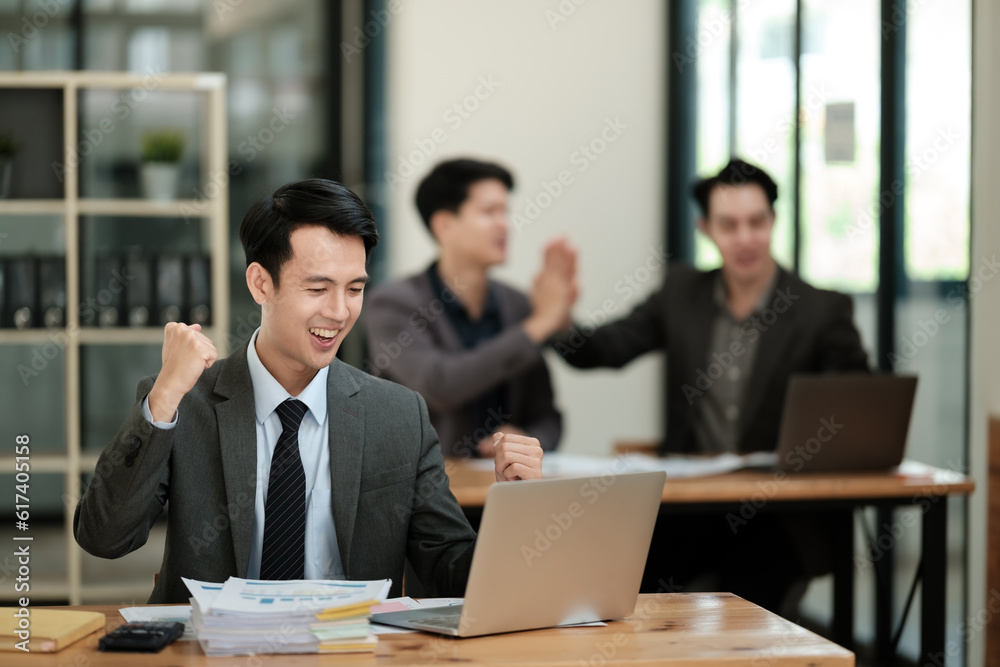 Young handsome asian businessman success working in the office looking to a computer. Young handsome asian businessman success working in the office looking to a computer.