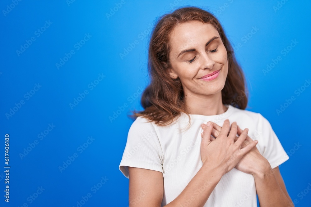 Young beautiful hispanic woman smiling confident with hands on heart over isolated blue background Young beautiful hispanic woman smiling confident with hands on heart over isolated blue background