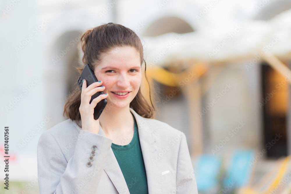 Young Adult Woman Smiling and Talking on Smartphone, Using Wireless Technology for Communication in Occupation Young Adult Woman Smiling and Talking on Smartphone, Using Wireless Technology for Communication in Occupation