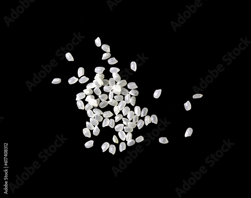 Heaps of uncooked Japanese short grain rice piled together isolated on black background. 