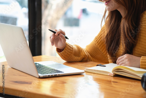 Happy latin girl college student watching distance online learning class, remote university webinar or having talk on laptop video call and use notebook to virtual meeting seminar at home or campus