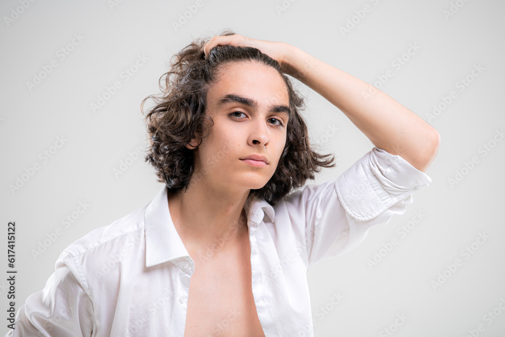 Portrait of a handsome young man with lush curly hair on a white background