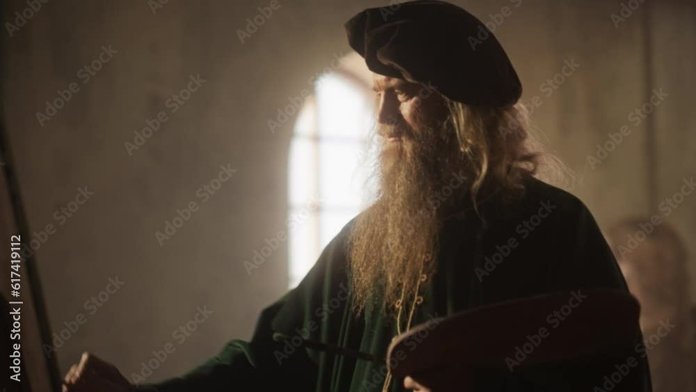 Dynamic Camera Movement: Dolly Portrait of the Brilliant Leonardo Da Vinci Drawing Passionately on Canvas in his Workshop. Inspired Renaissance Painter Making his Masterpiece with Big Brush Strokes