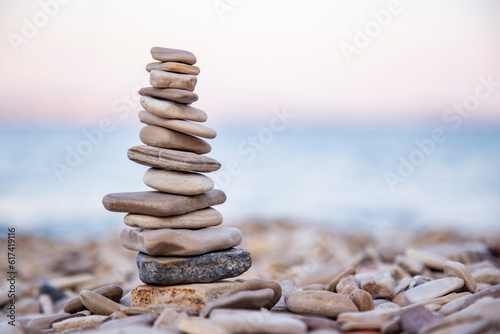 Fotografie The pebble tower balances harmony stones on the Aegean sea beach at sunset