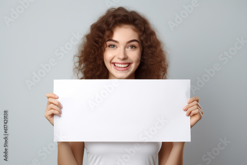 Beautiful woman holding a blank billboard isolated on white background