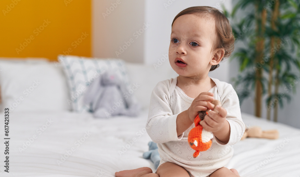 Adorable hispanic boy sitting on bed with dolls at bedroom Adorable hispanic boy sitting on bed with dolls at bedroom