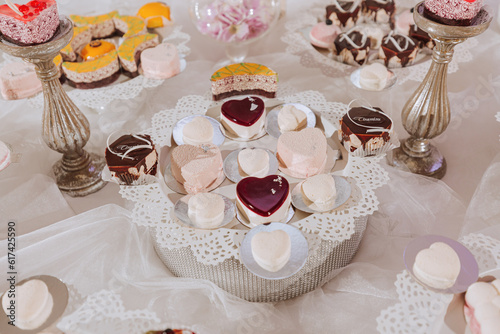 Festive dessert table with sweets. Wedding candy bar, various cakes, chocolates on stands.