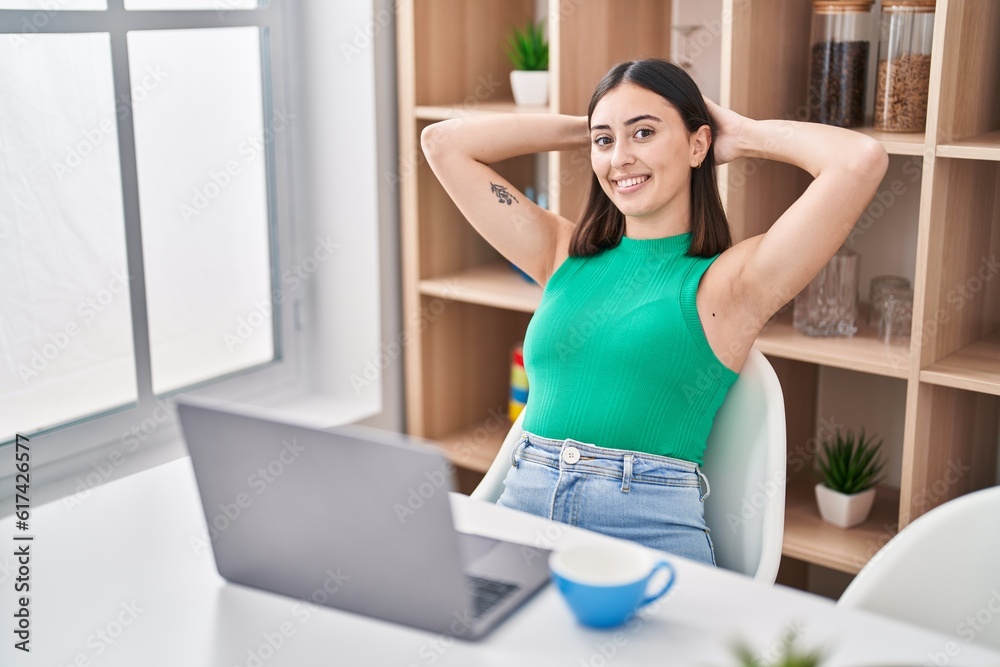 Young hispanic woman using laptop sitting on table at home Young hispanic woman using laptop sitting on table at home