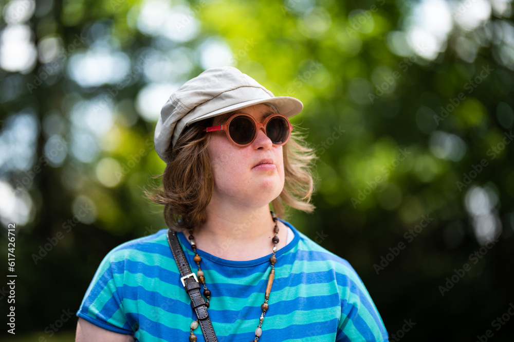 Outdoor portrait of a 40 yo woman with the Down Syndrome, wearing sunglasses and a hat, Belgium Outdoor portrait of a 40 yo woman with the Down Syndrome, wearing sunglasses and a hat, Belgium