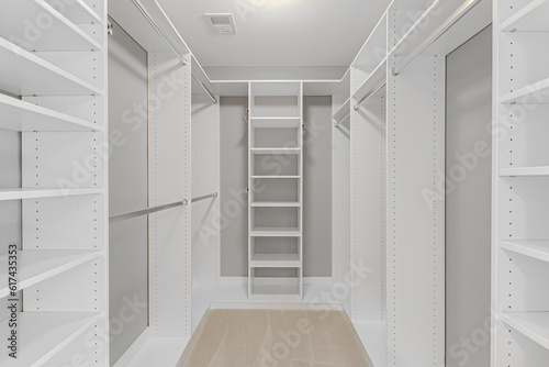 Luxury Empty Primary White Bedroom Closet With Tons Of Storage